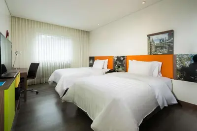 a hotel room with two beds and a television at Hampton by Hilton Medellin in Medellín