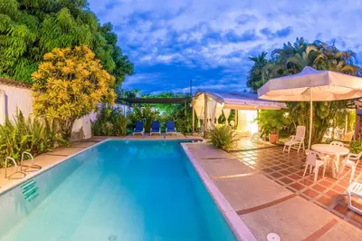 a swimming pool with a table and chairs and an umbrella at Casamarilla in Mariquita