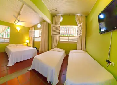 a room with two beds and a flat screen tv at Casamarilla in Mariquita