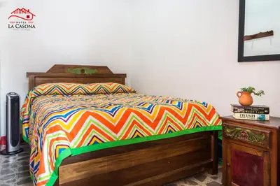 a bedroom with a bed with a colorful comforter at Hotel La Casona in Jardin
