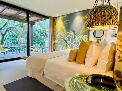 a bedroom with a large white bed with a table at Patio del Mundo in Medellín