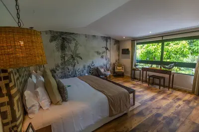 a bedroom with a bed and a desk and a window at Patio del Mundo in Medellín