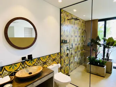 a bathroom with a toilet and a sink and a mirror at Patio del Mundo in Medellín