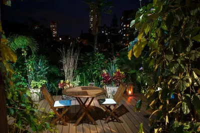 a wooden deck with a table and chairs in a garden at Patio del Mundo in Medellín