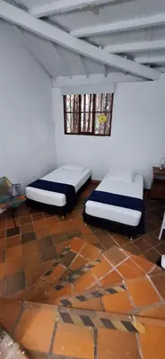 two beds in a room with a tile floor at Yolo Hostel Medellin in Medellín