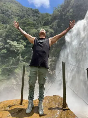 a man standing on top of a rock with his arms out at Yolo Hostel Medellin in Medellín