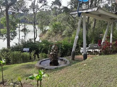 a fountain in a yard with a view of a river at Cabañas La Honda in Guatapé