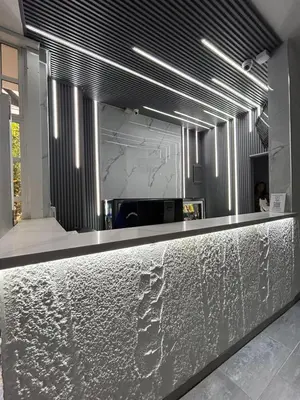a lobby with a counter with a silver counter top at Hotel Monarca in Medellín