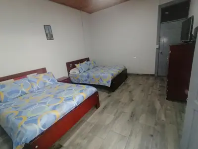 a bedroom with two beds and a television in it at ANGIE`s HOUSE in Manizales