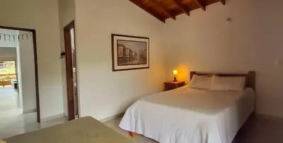 a bedroom with a white bed and a lamp on a table at La Casa Del Sol in Jardin