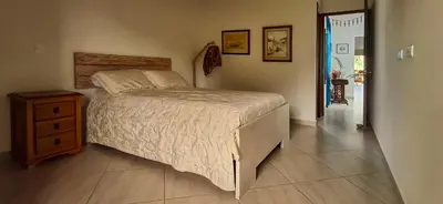 a bedroom with a bed and a wooden dresser and a door at La Casa Del Sol in Jardin