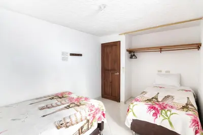 a bedroom with two beds and a door at Fami Hotel Vive Jardin in Jardin