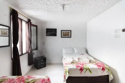 a white bedroom with a bed and a window at Fami Hotel Vive Jardin in Jardin