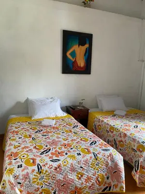 a bedroom with two beds and a painting on the wall at Europa Ecotours in Jardin