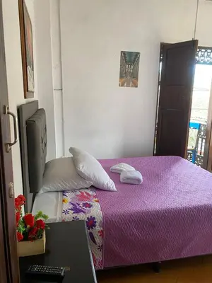 a bedroom with a purple bed and a desk with a laptop at Europa Ecotours in Jardin