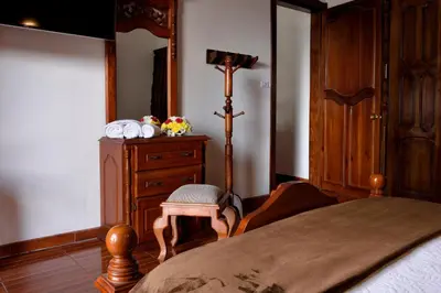 a bedroom with a bed and a chair and a dresser at Las Marías Family Home - Urbano & Campestre in Salamina