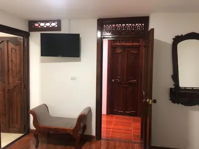 a room with a door and a chair and a mirror at Las Marías Family Home - Urbano & Campestre in Salamina