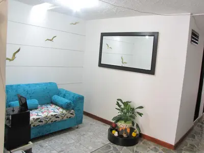 a living room with a blue couch and birds on the wall at El Cable Hostal in Manizales