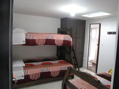 two bunk beds in a room with a mirror at El Cable Hostal in Manizales