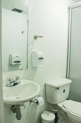 a bathroom with a sink and a toilet and a mirror at El Cable Hostal in Manizales