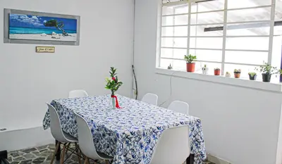 a dining room table with a blue and white table cloth at El Cable Hostal in Manizales