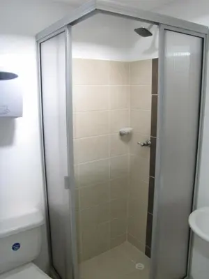 a shower with a glass door in a bathroom at El Cable Hostal in Manizales