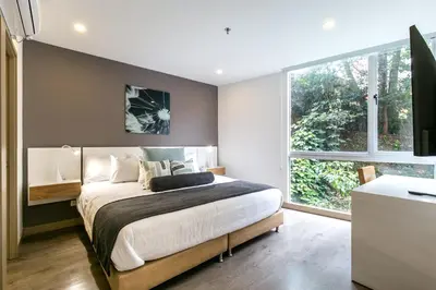 a bedroom with a large bed and a large window at Soul Lifestyle Hotel in Medellín