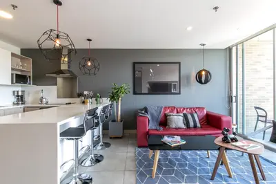a living room with a red couch and a kitchen at Soul Lifestyle Hotel in Medellín