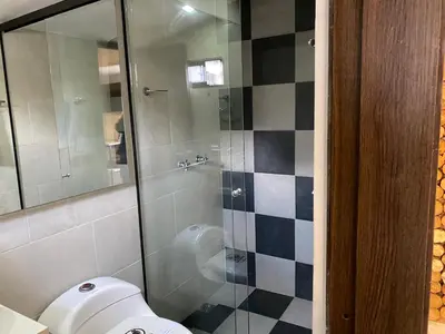 a bathroom with a toilet and a glass shower at Rivière Boutique Hotel in Medellín