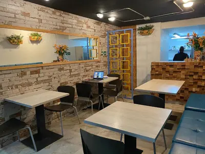 a restaurant with tables and chairs with a laptop at Rivière Boutique Hotel in Medellín