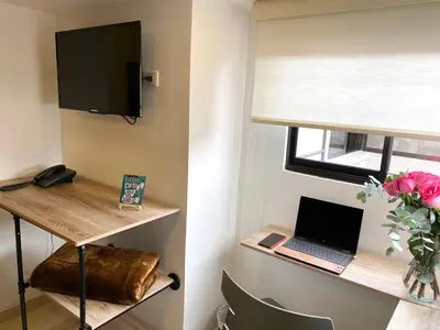 a room with a desk with a laptop and a window at Rivière Boutique Hotel in Medellín