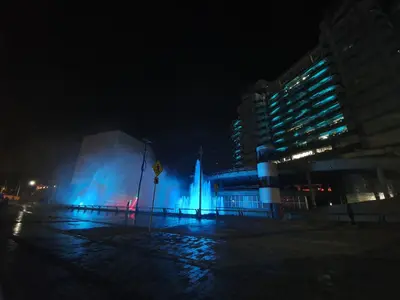 a building with a fountain in front of it at night at Rivière Boutique Hotel in Medellín
