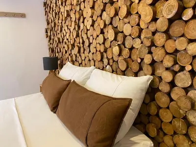 a bed with two pillows in front of a wall of wood at Rivière Boutique Hotel in Medellín