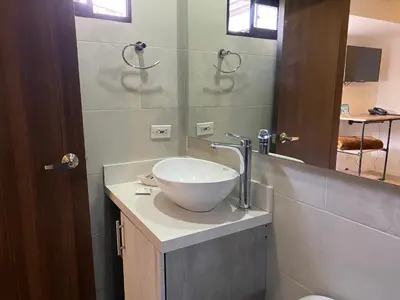 a bathroom with a bowl sink and a mirror at Rivière Boutique Hotel in Medellín