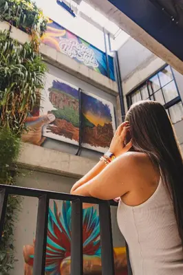 a woman in a white dress talking on a cell phone at Los Patios Hostel Medellin in Medellín