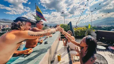 a group of people holding hands on a rooftop at Los Patios Hostel Medellin in Medellín