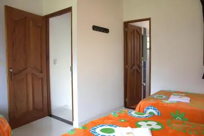 a bedroom with a bed with an orange blanket and a mirror at Hotel Internacional Jardín in Jardin