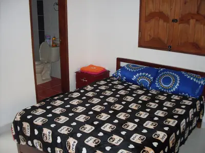 a bedroom with a bed with a black and blue comforter at Hotel Internacional Jardín in Jardin
