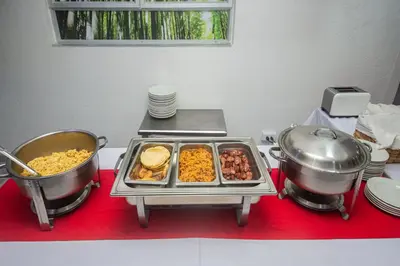 a table with two pots and pans of food on it at Hotel Laureles Plaza in Medellín