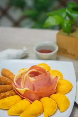 a plate of food with meat and chips on a table at Hotel Laureles Plaza in Medellín