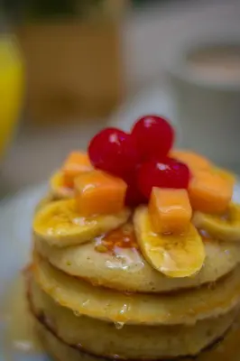 a stack of pancakes with fruit on top of them at Hotel Laureles Plaza in Medellín