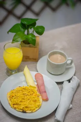 a table with two plates of food and a cup of coffee at Hotel Laureles Plaza in Medellín