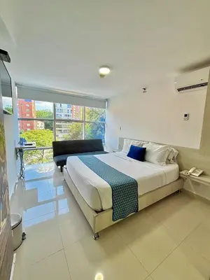 a bedroom with a bed and a large window at Hotel Laureles Plaza in Medellín