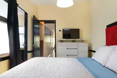 a bedroom with a large bed and a television at The Lofts @ 11 in Medellín
