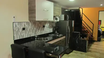 a kitchen with a black counter top and a refrigerator at The Lofts @ 11 in Medellín