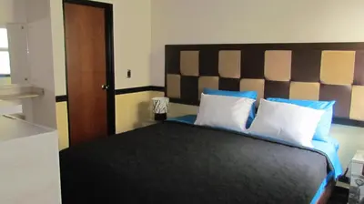 a bedroom with a large bed with blue and white pillows at The Lofts @ 11 in Medellín