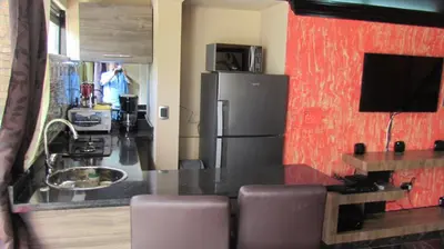 a kitchen with a black counter and a refrigerator at The Lofts @ 11 in Medellín