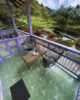 a porch with two chairs and a table with a view at Hotel Lago Valdivia in Jardin