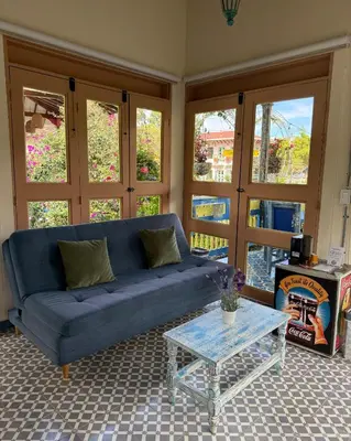 a living room with a blue couch and a table at Hotel Lago Valdivia in Jardin