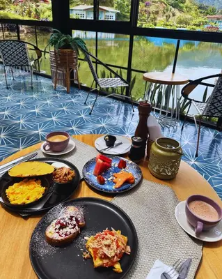 a table with plates of food on top at Hotel Lago Valdivia in Jardin